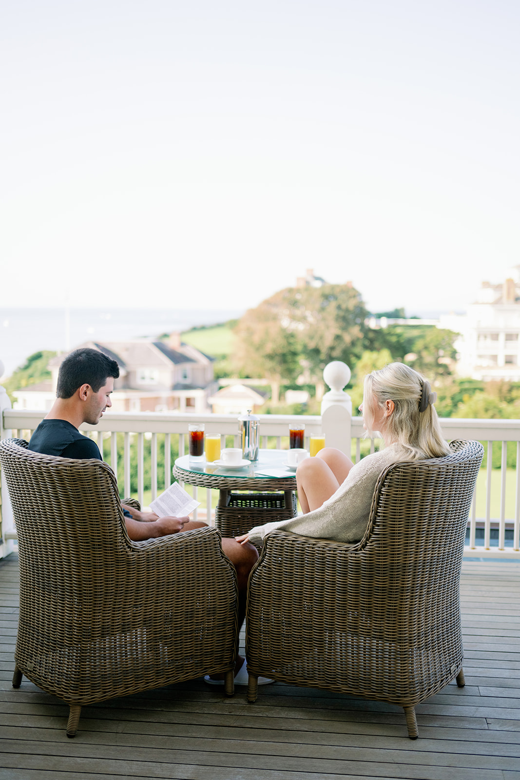 Bride and groom reading their vows over coffee on the balcony of their Ocean House hotel suite.  