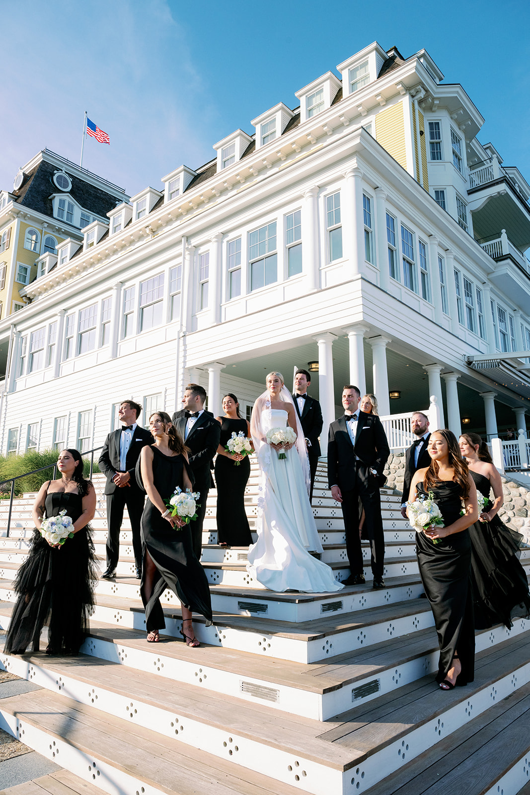 All black wedding party posing on the Ocean House Rhode Island hotel steps with the bride and groom. 