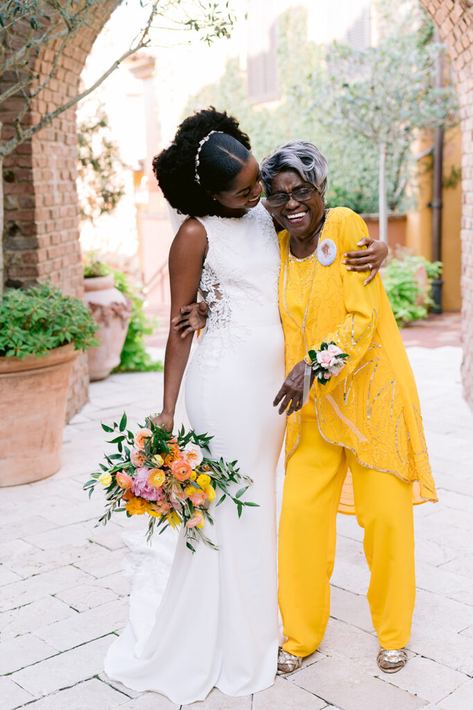 Candid photo with a bride and her grandma in a colorful yellow outfit.