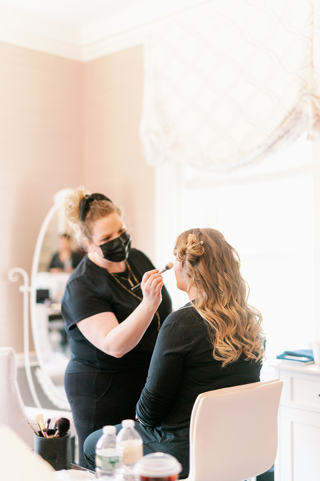 Bridesmaid getting her makeup done at a New York wedding at Pine Hollow Country Club. 