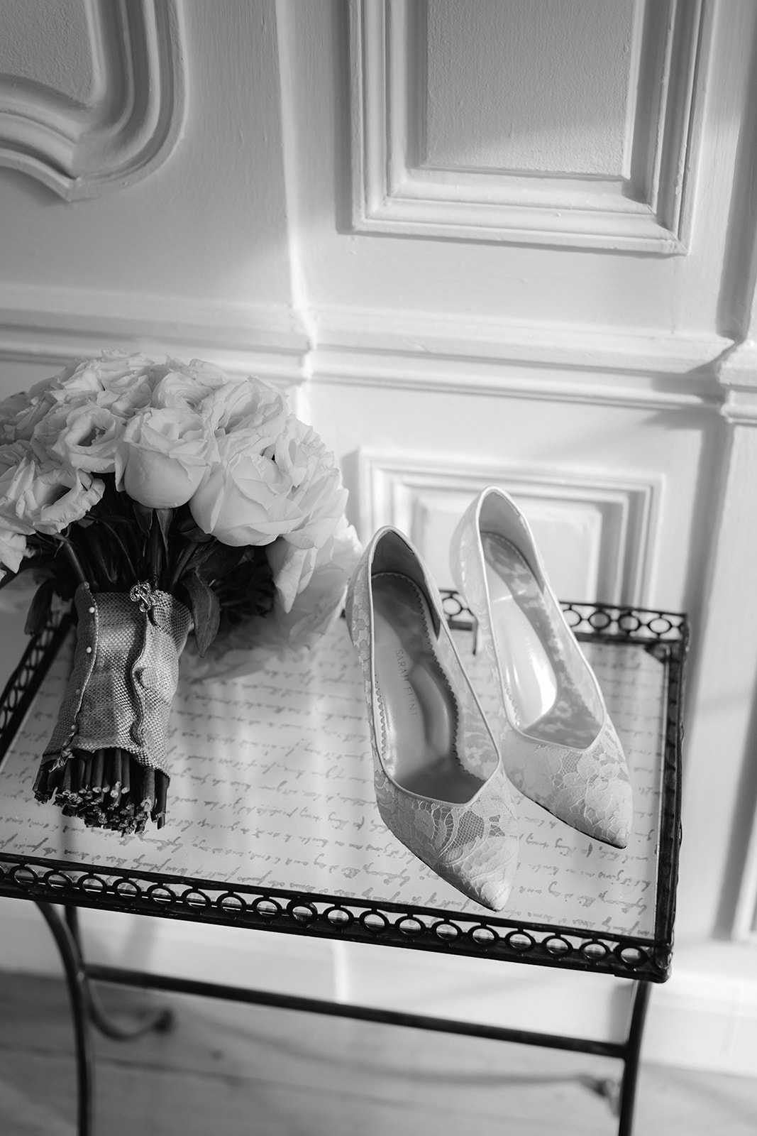 Black and white editorial bridal detail flat lay with shoes and bouquet. 