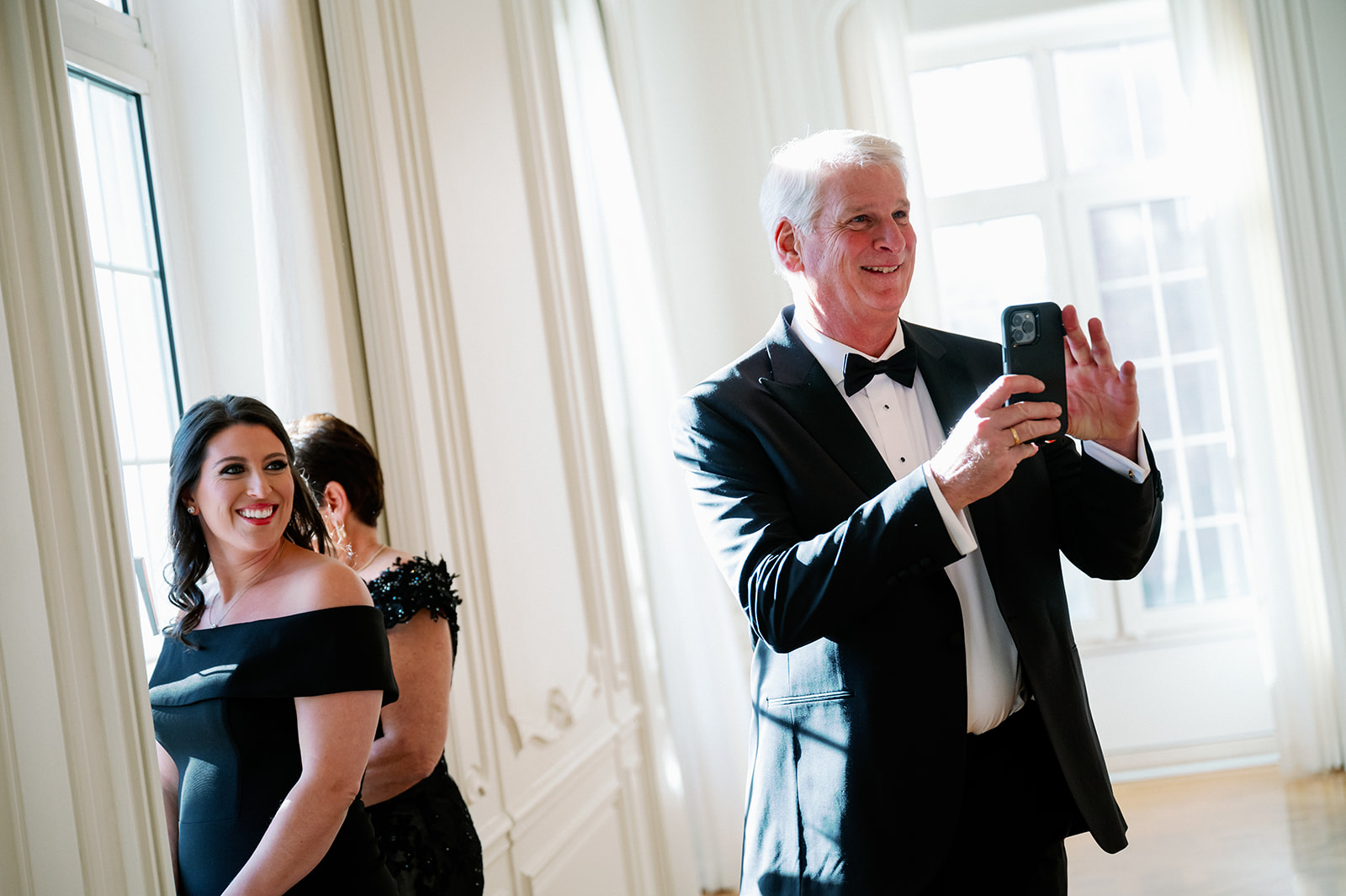 Groom's father videoing the best man surprise first look. 