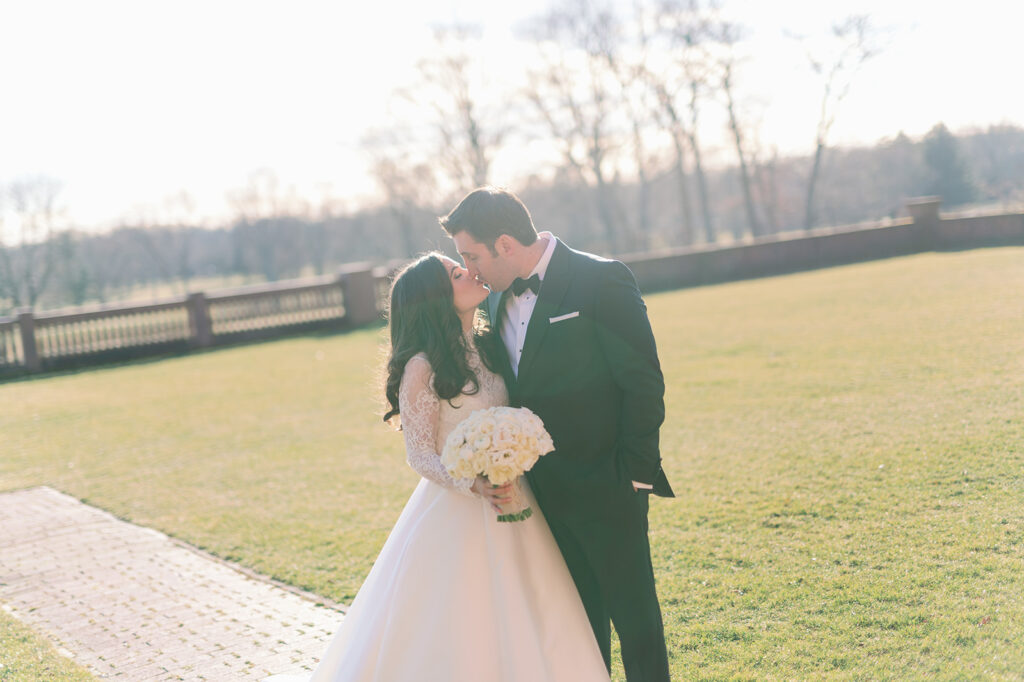 Bride and groom kissing outside their venue Pine Hollow Country Club.