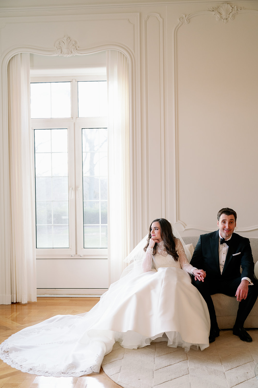 Editorial wedding portrait of bride and groom sitting on a couch at Pine Hollow Country Club.
