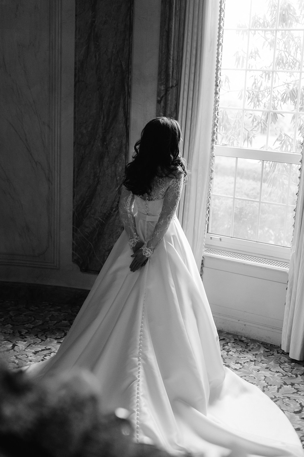 Bride standing in front of a window editorial wedding portrait. 