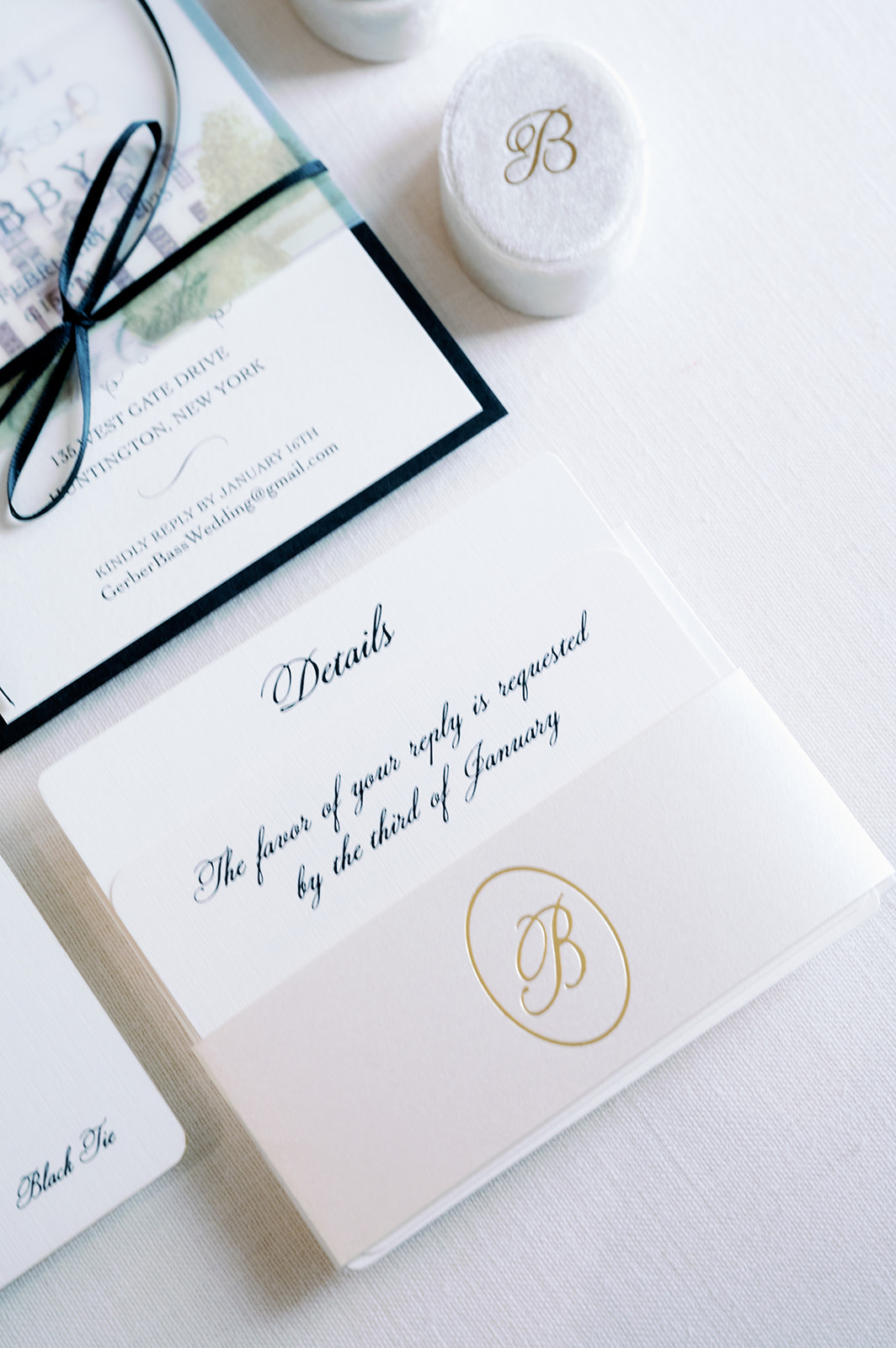 Simple white and gold wedding invitation detail flat lay.