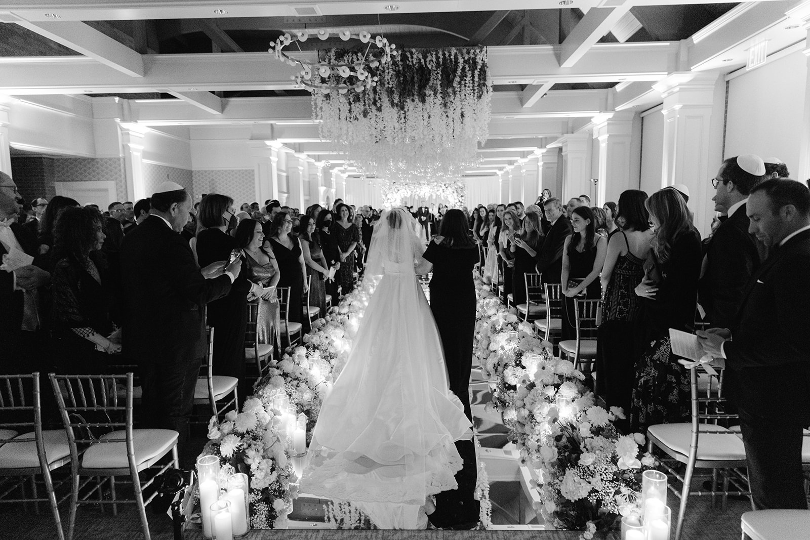 Bride walking down a reflective aisle lined with florals at Pine Hollow Country Club.