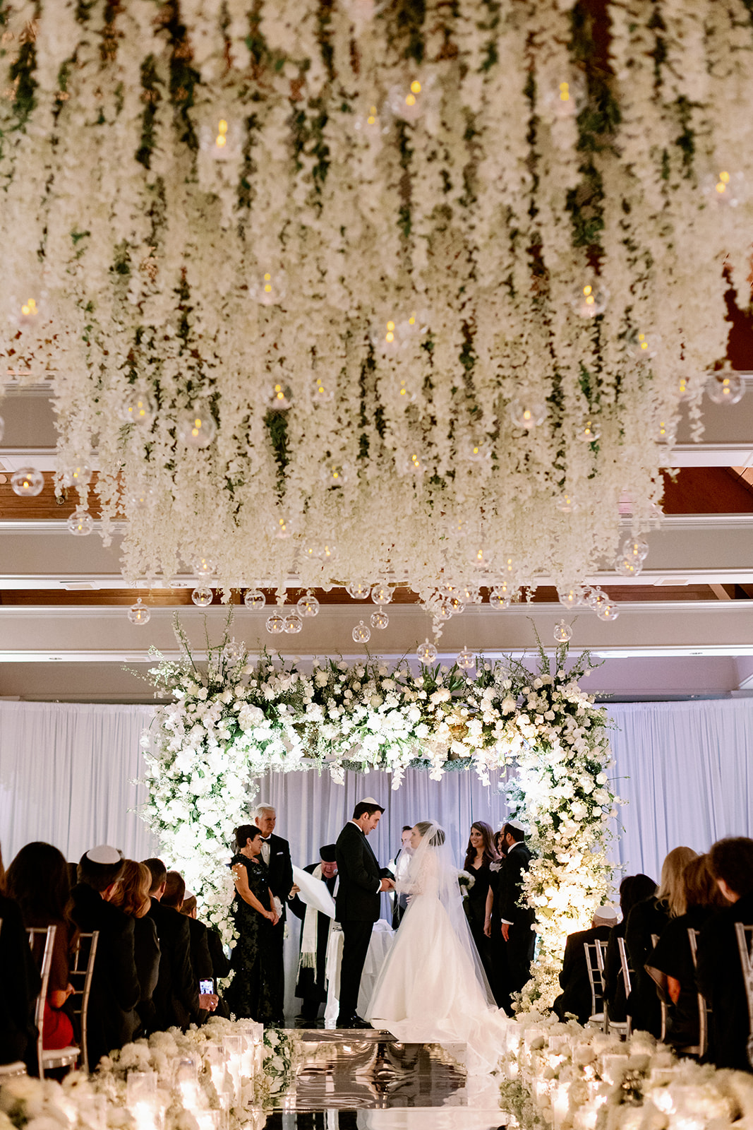 Luxury floral-filled wedding ceremony with a large floral chuppah at Pine Hollow Country Club.