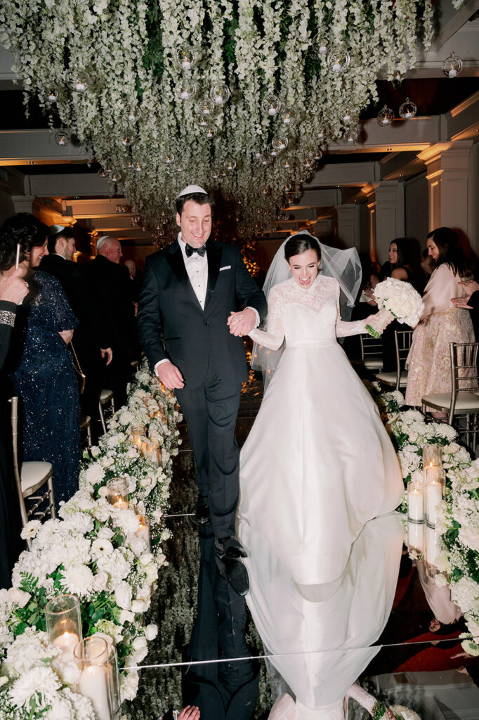 Direct flash indoor wedding ceremony bride and groom recessional at Pine Hollow Country Club. 