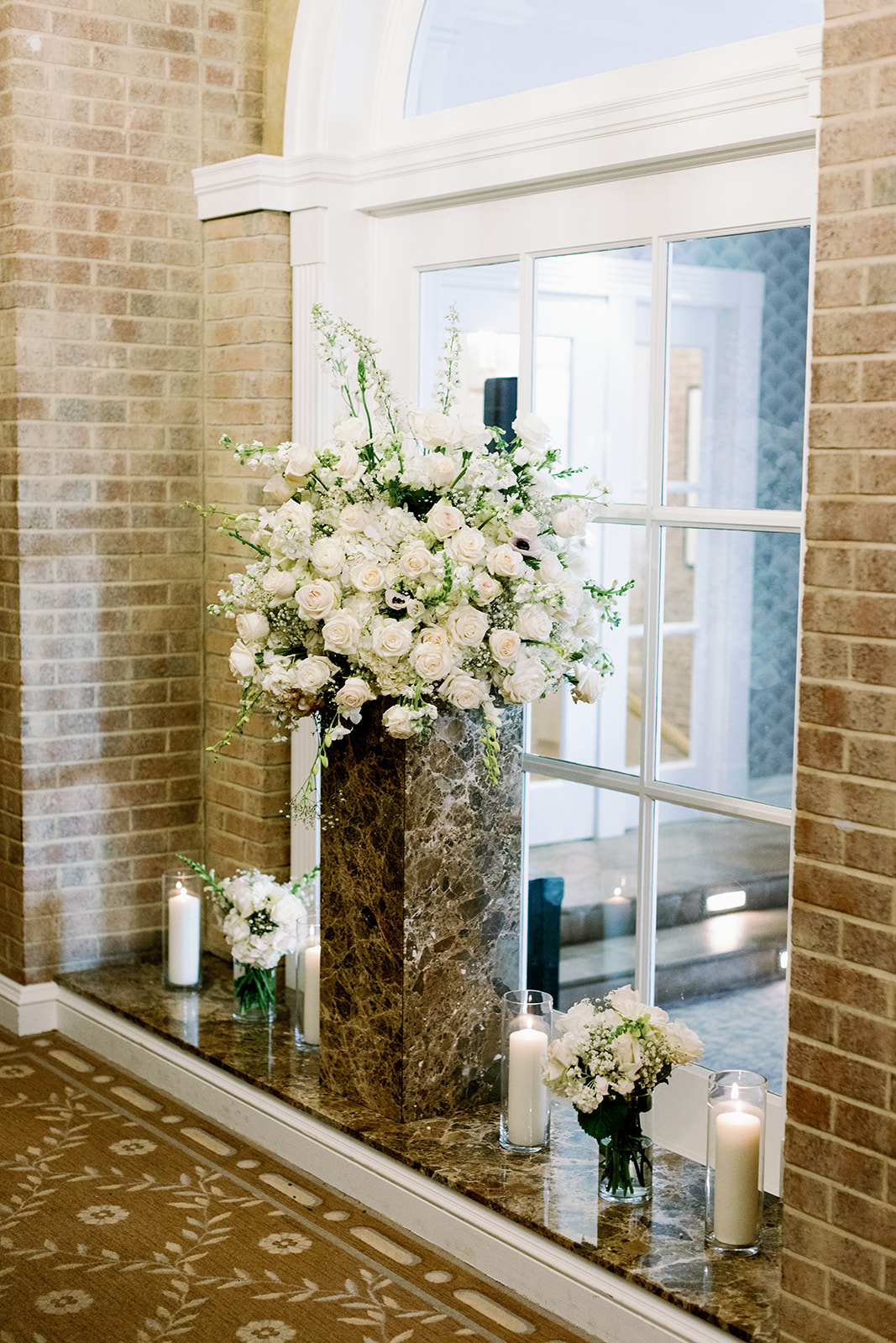 Large floral arrangements on a marble stand at Pine Hollow Country Club.