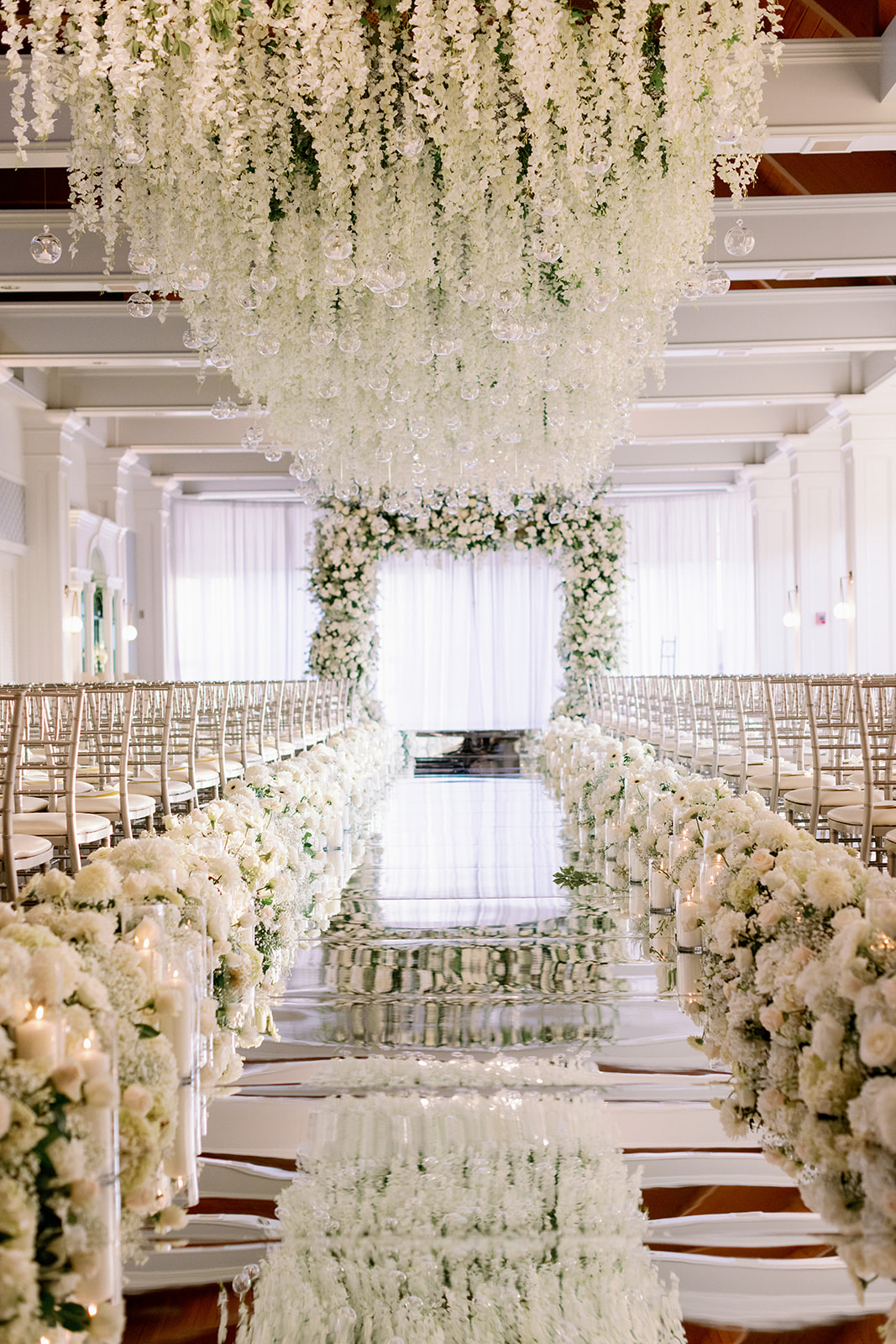 Lavish floral wedding ceremony with a reflective floor at Pine Hollow Country Club.