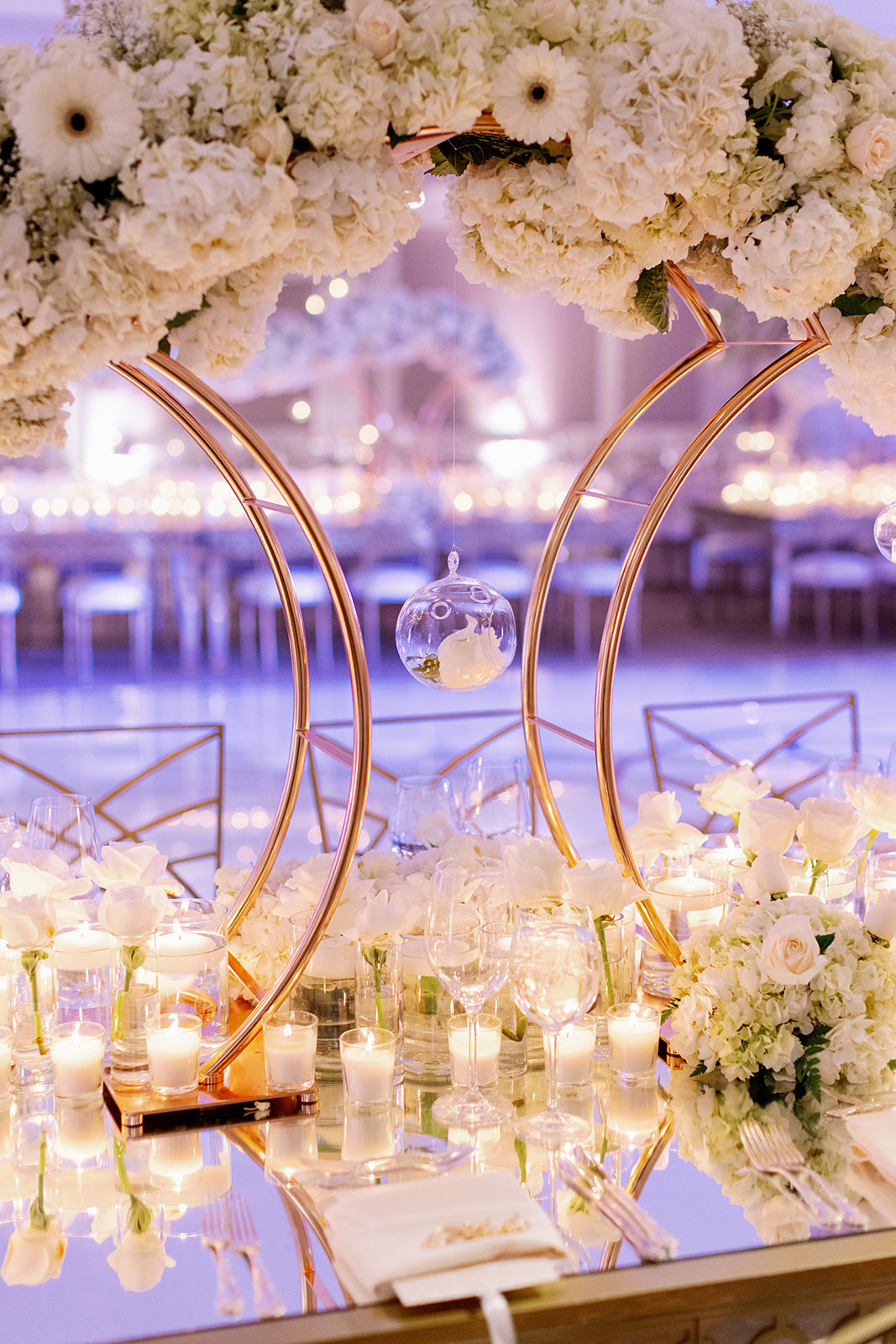 Glam wedding floral table centerpiece with candles in glass orbs. 