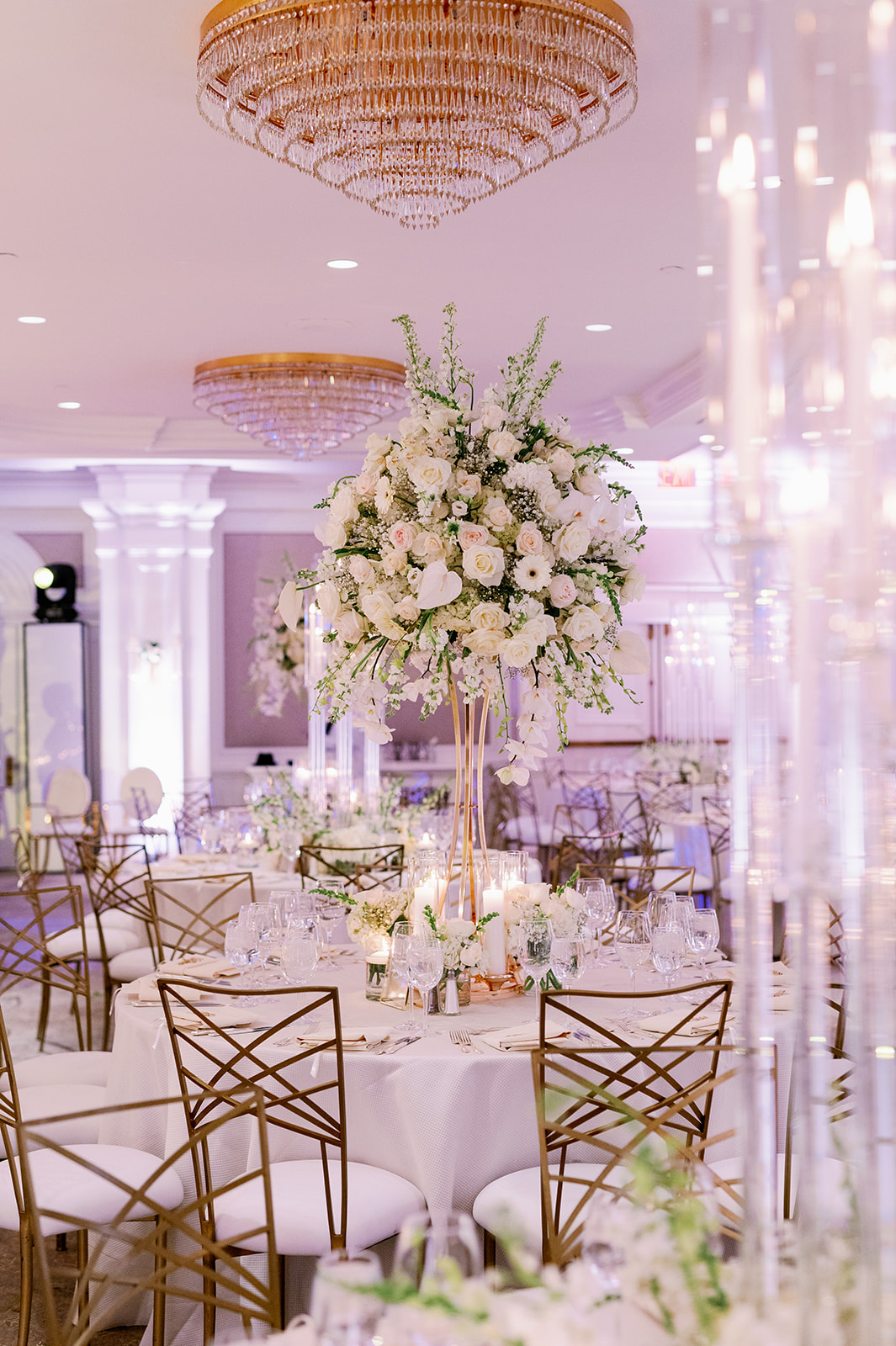 Luxury white floral wedding reception with gold accents. 