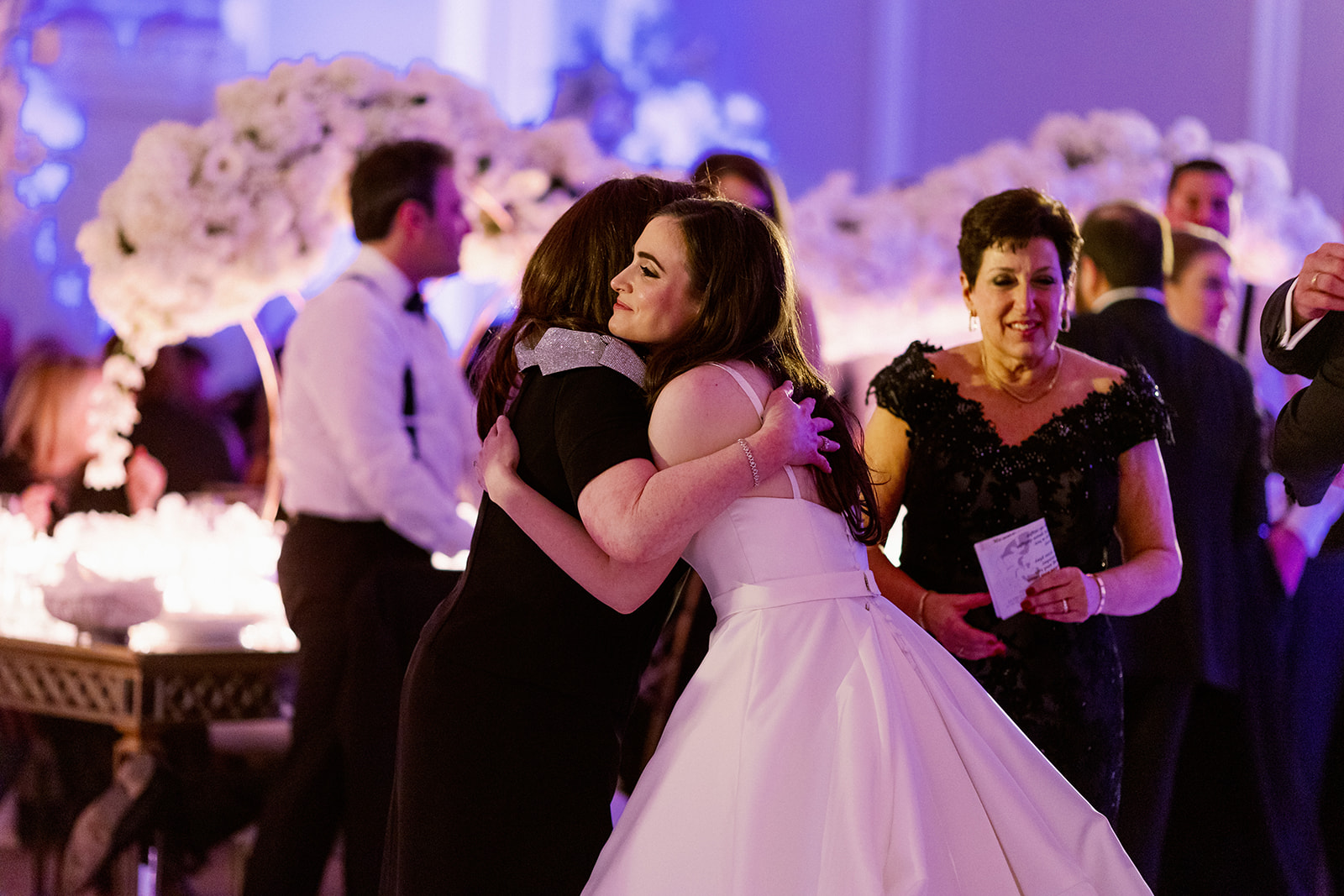 Bride hugging mom after emotional reception speech.