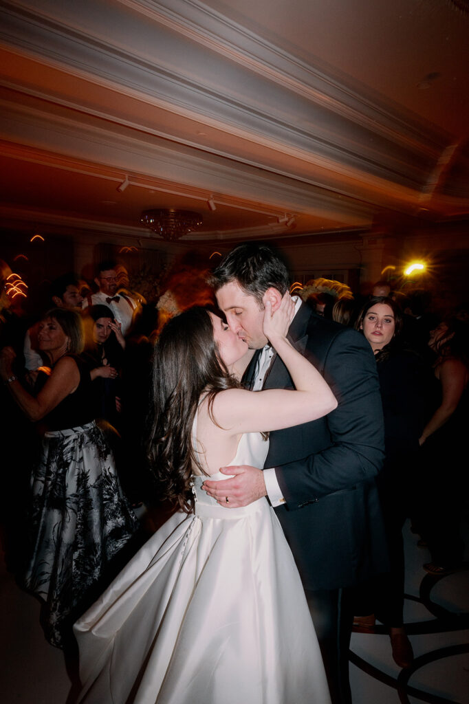 Direct flash bride and groom kissing during dance party at Pine Hollow Country Club.