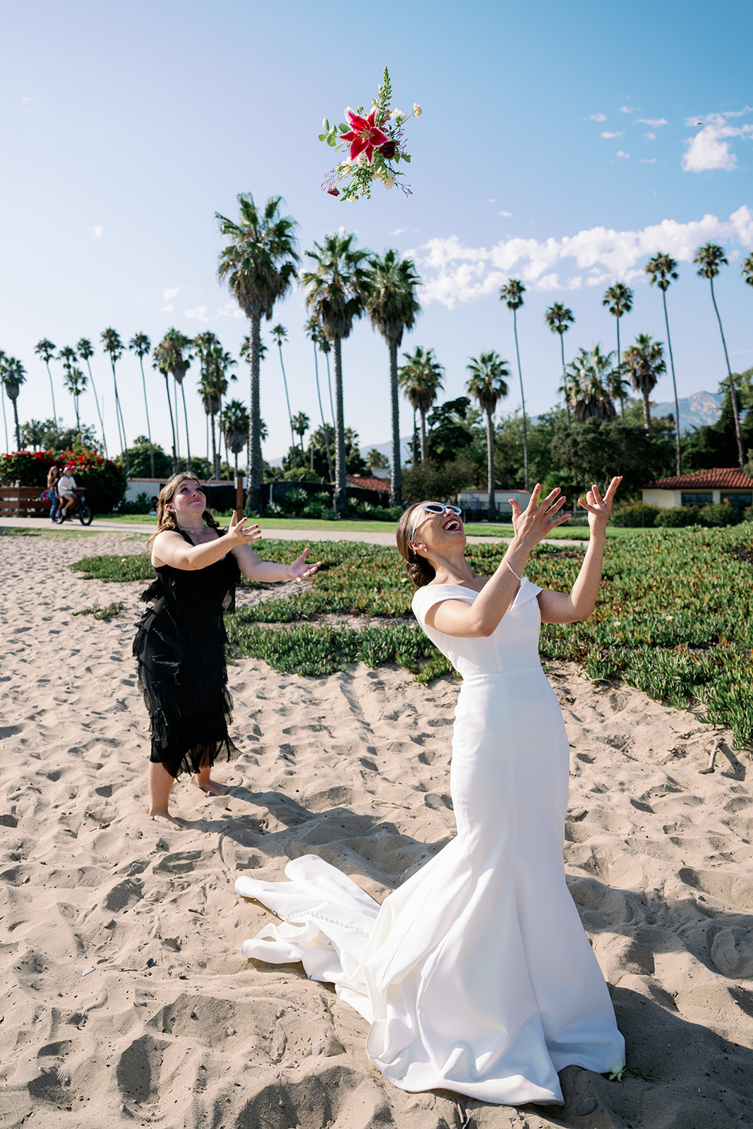 Bride bouquet toss to single cousin at the Santa Barbara beach. 