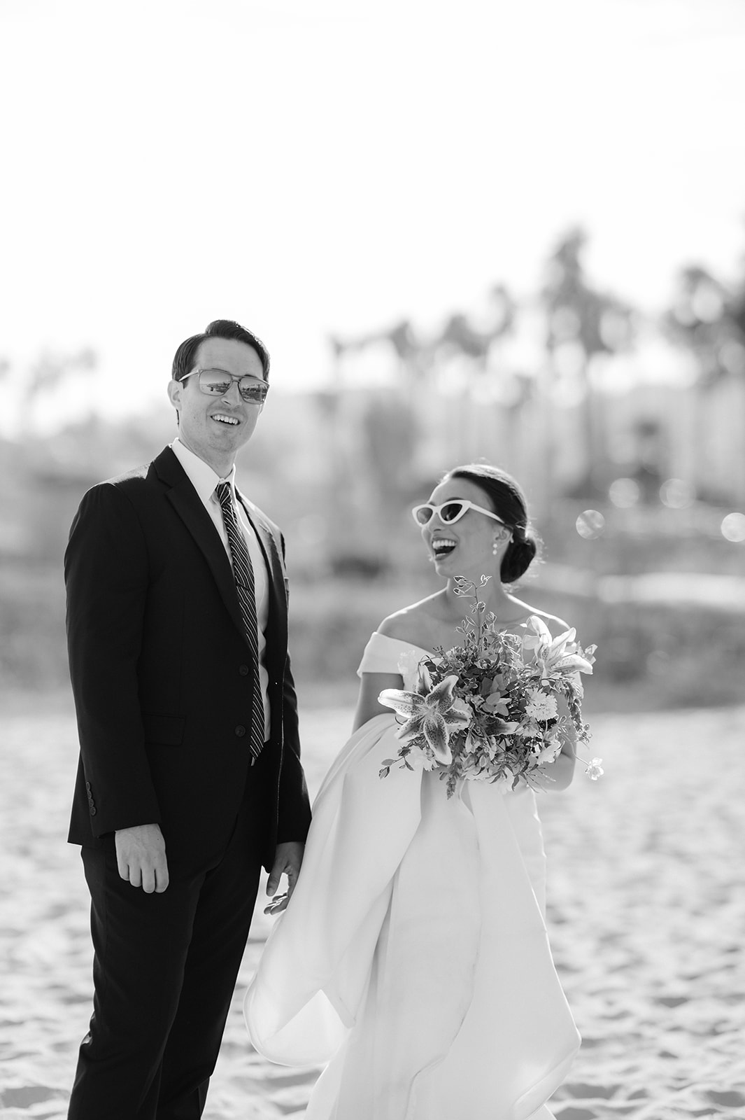 Bride and groom beach photo in Santa Barbara wearing sunglasses. 