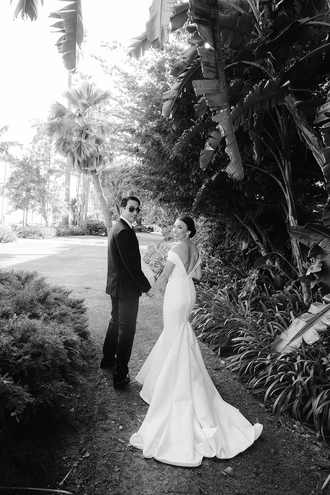 Bride and groom portrait framed by palm trees at the Santa Barbara Courthouse. 