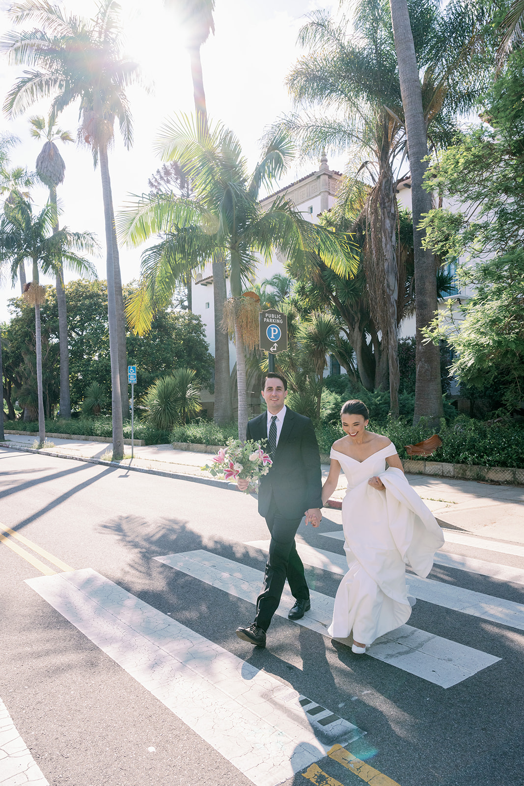 Bride and groom walking to the beach after their intimate Santa Barbara Courthouse wedding.