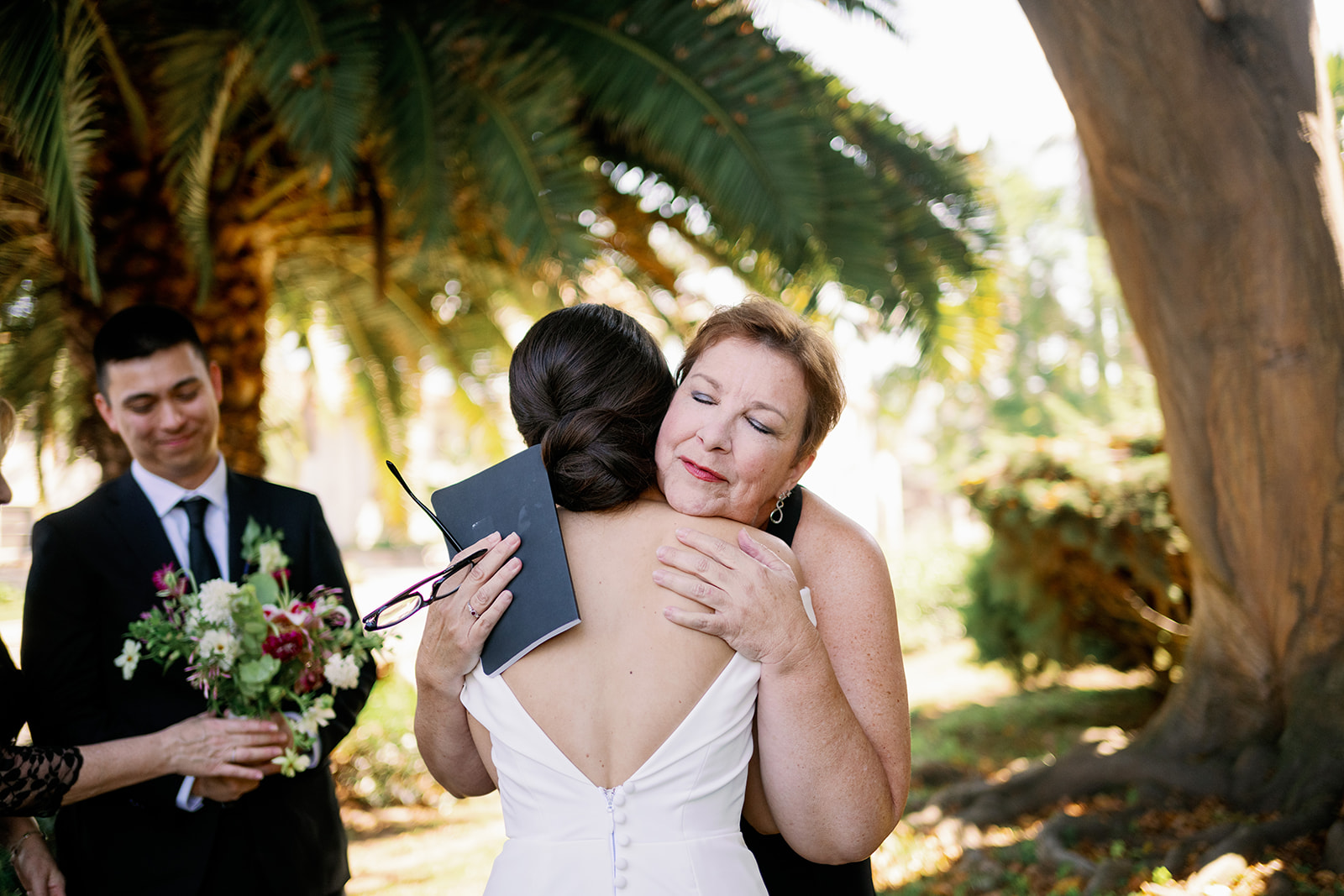 Bride hugging her aunt and ceremony officiant at the Santa Barbara Courthouse gardens.