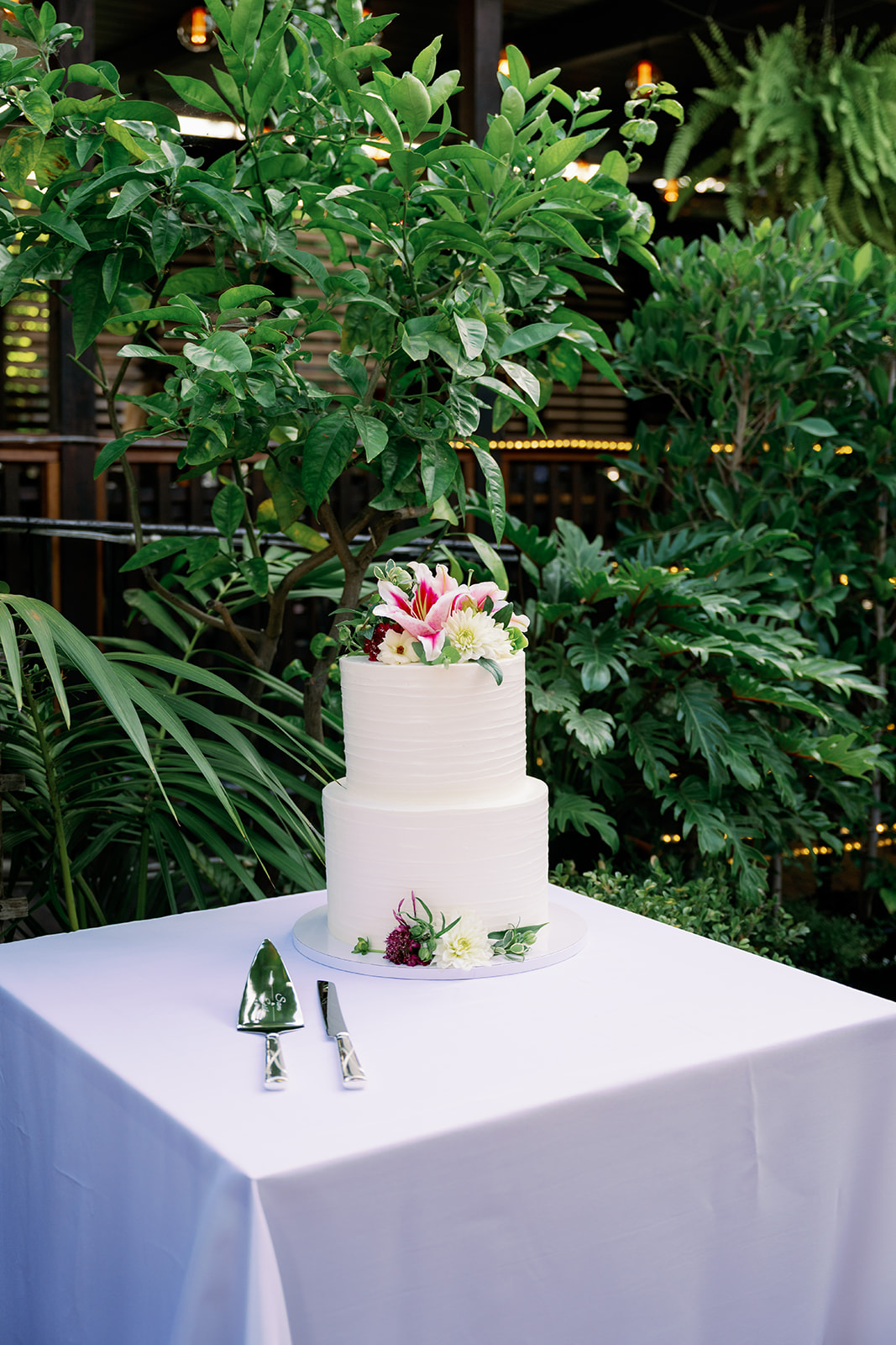 Two tier white wedding cake with lilies at Zaytoon's in Santa Barbara. 