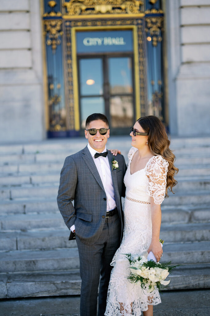Bride and groom portraits with sunglasses outside of San Francisco City Hall. 