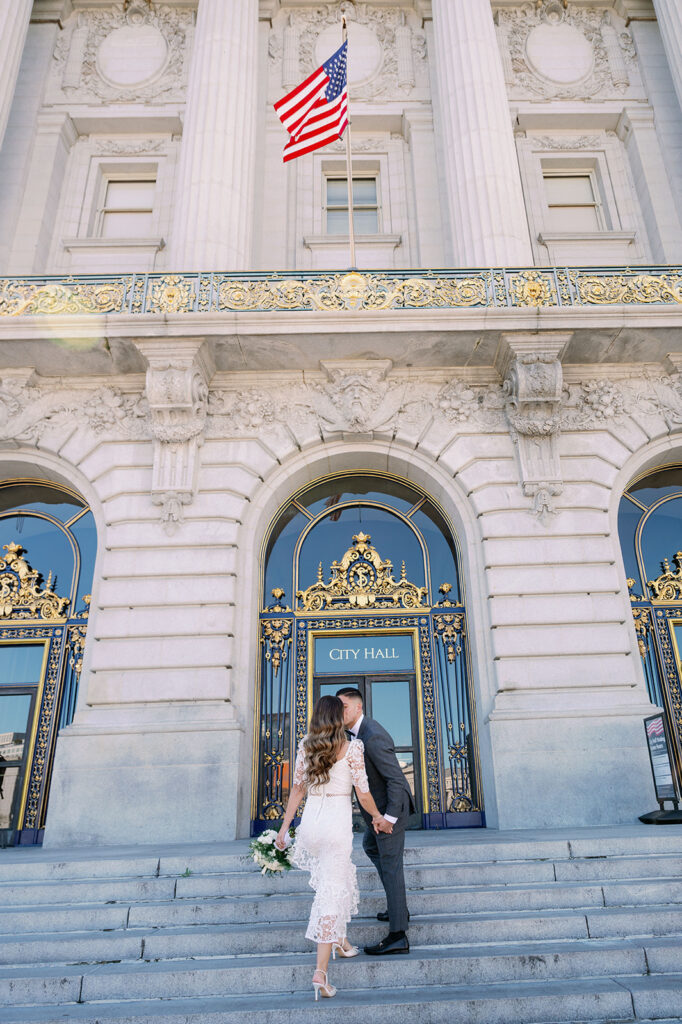 Candid bride and groom kissing outside SF City Hall.