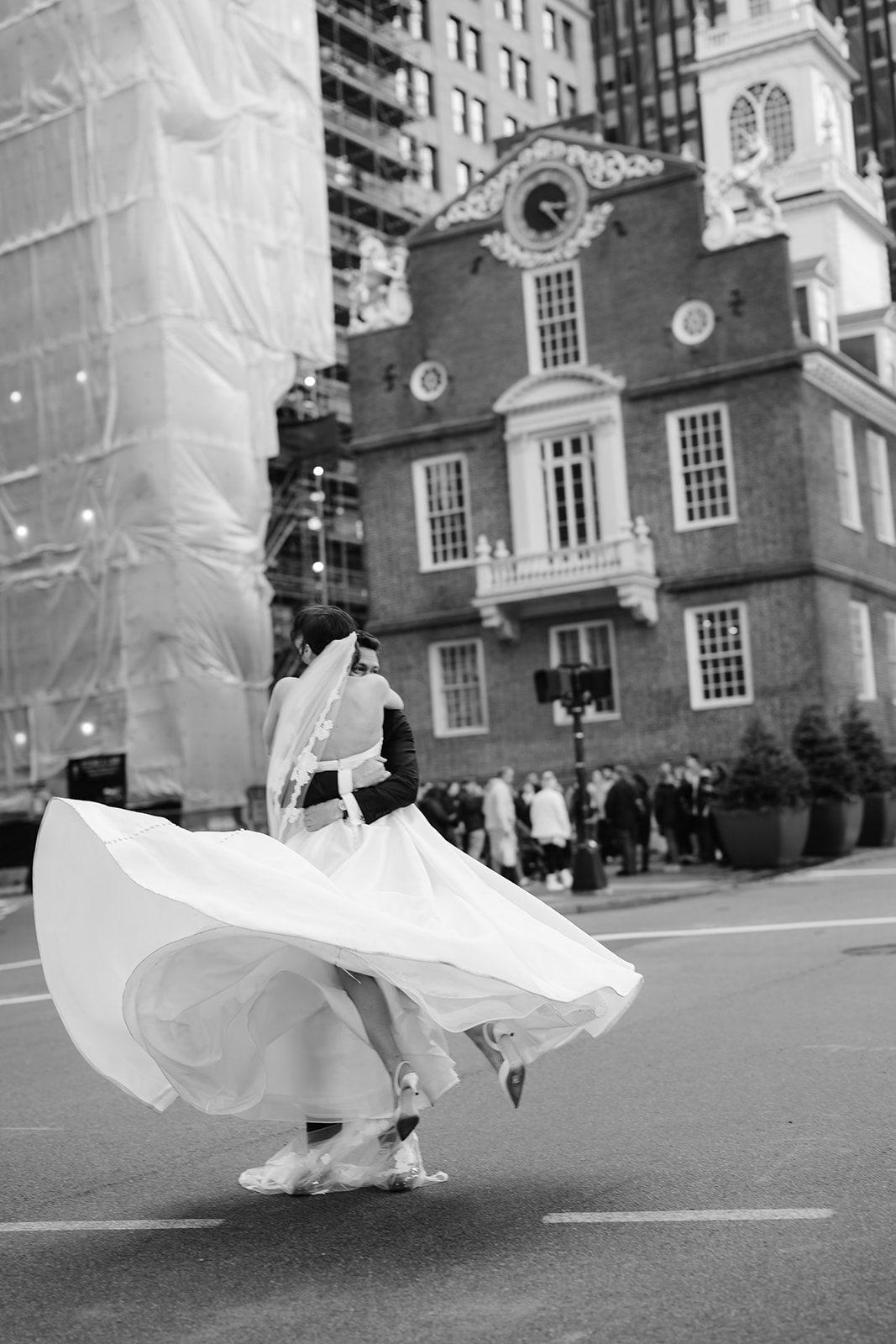 Bride and groom twirling in the street outside the Boston State House. 
