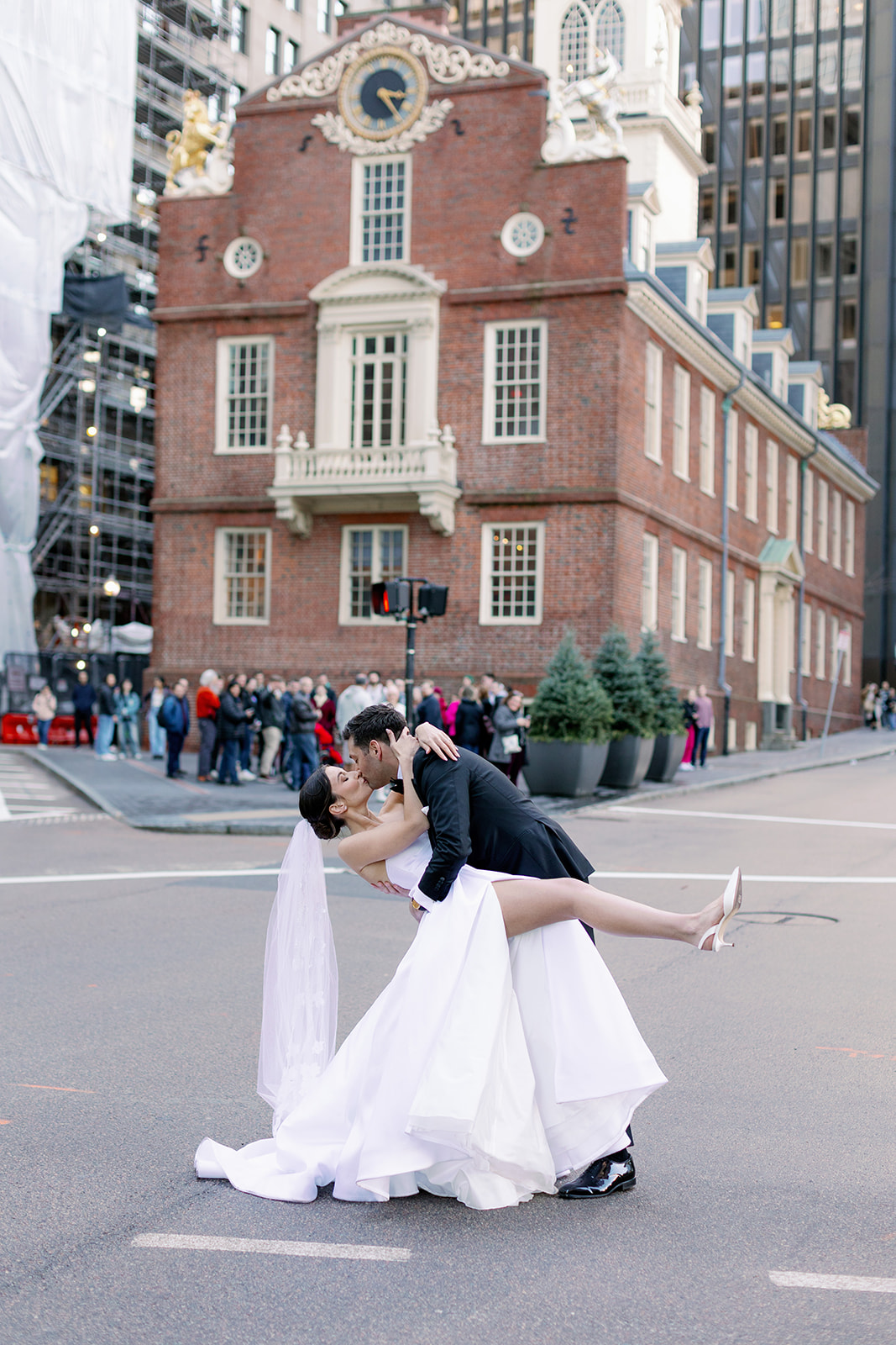 Bride and groom dipping kiss outside the Boston State House. 