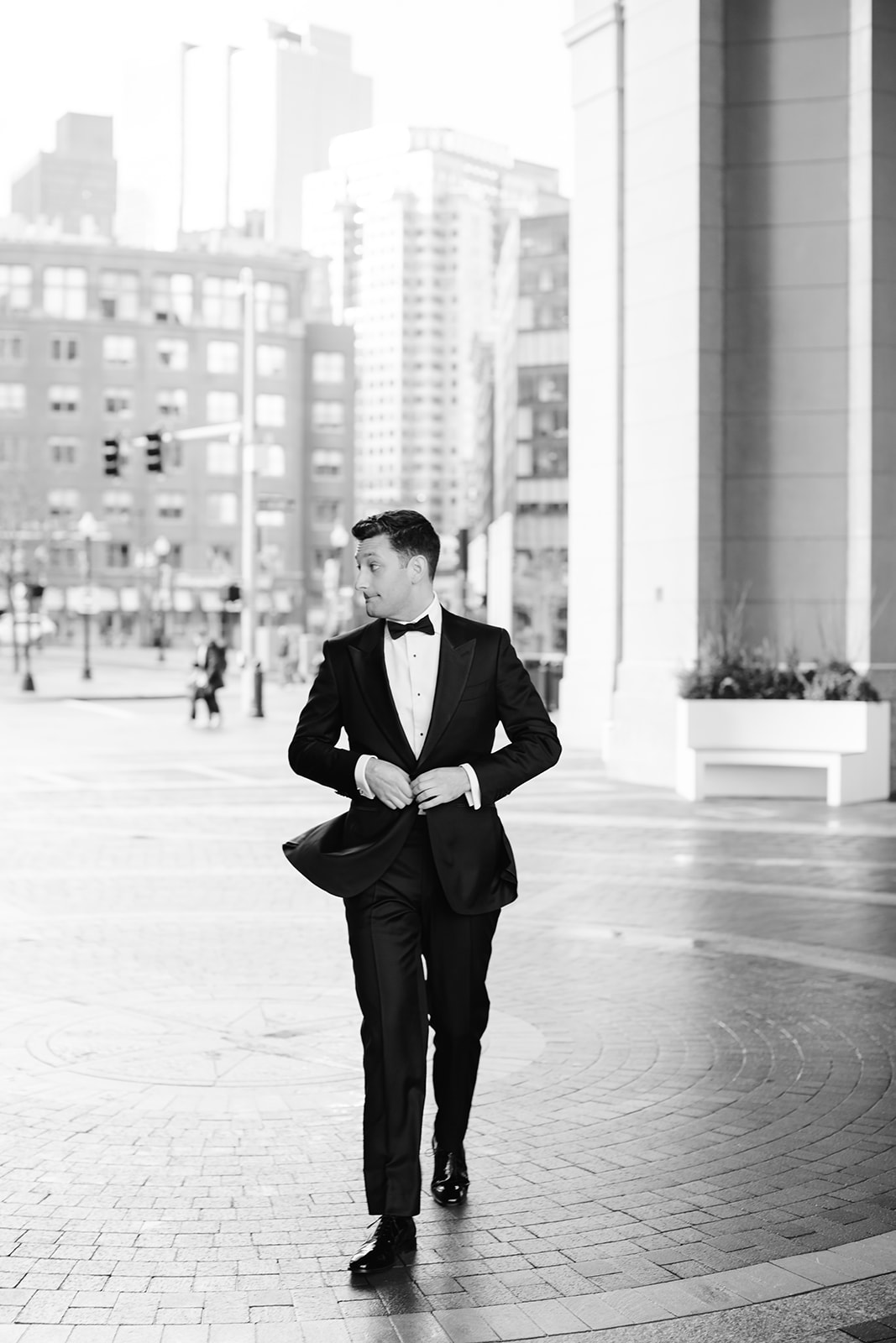Candid groom walking photo under the arch at Rowes Wharf.