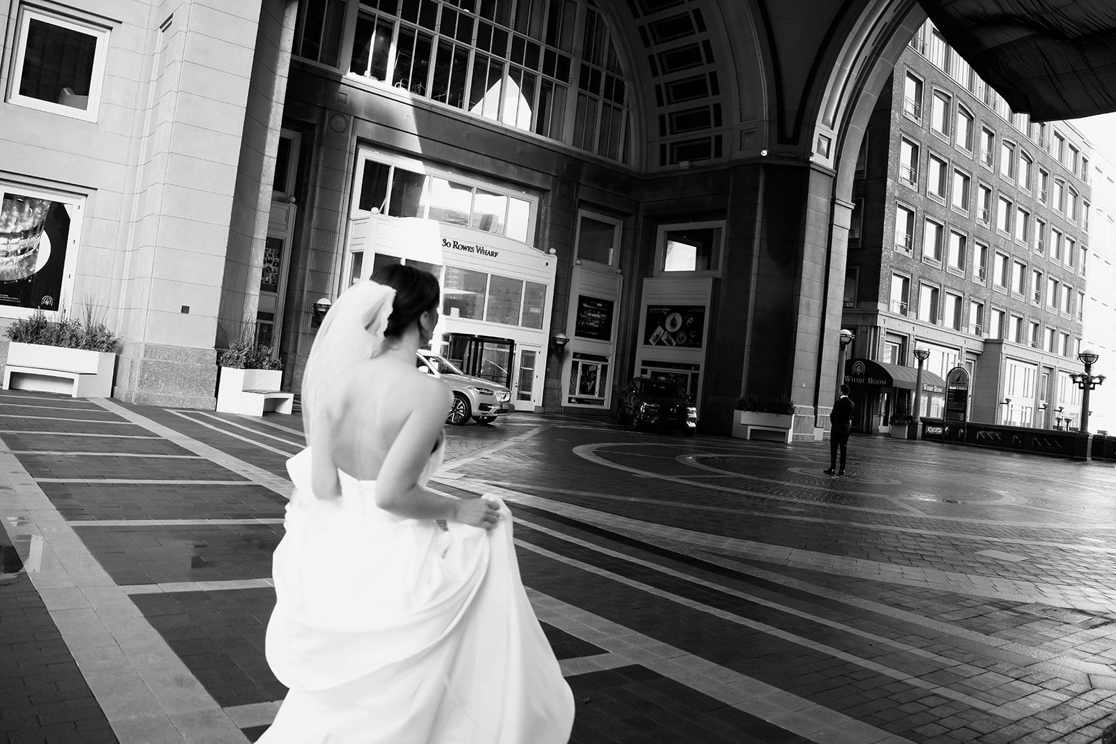 Bride toward the groom under the arch at the iconic Boston Harbor Hotel. 