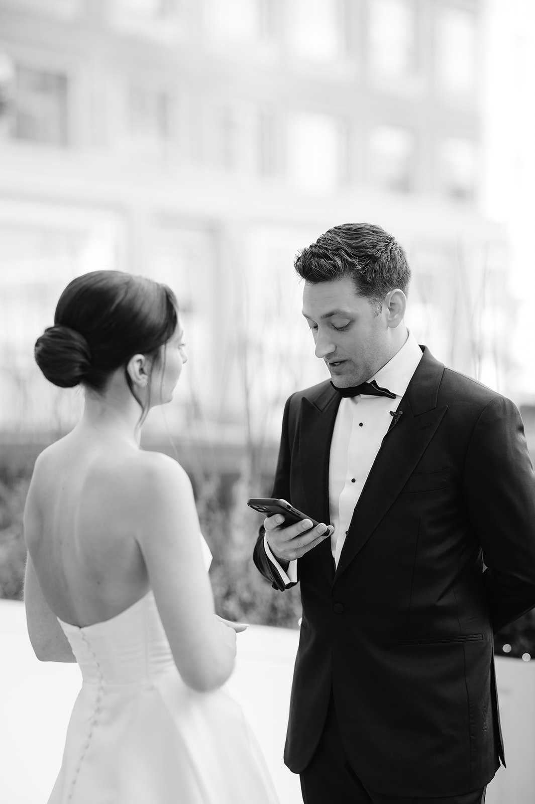 Groom reading his vows from his phone in private. 