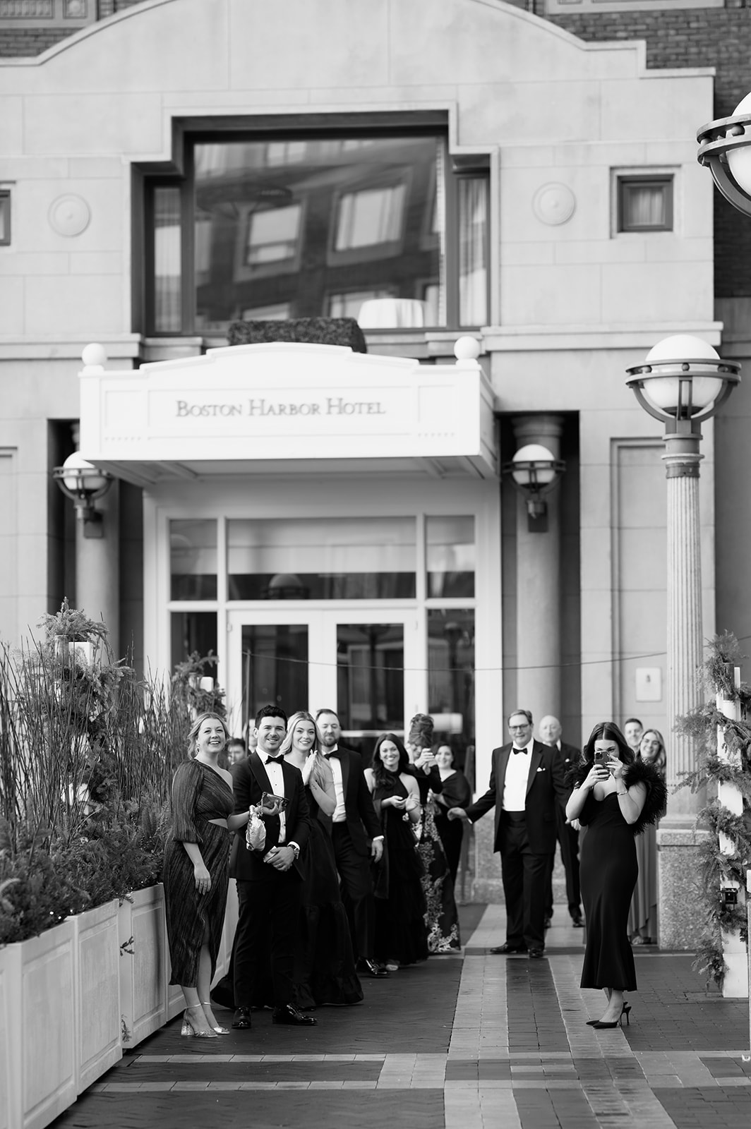 Wedding party standing outside the Boston Harbor Hotel. 
