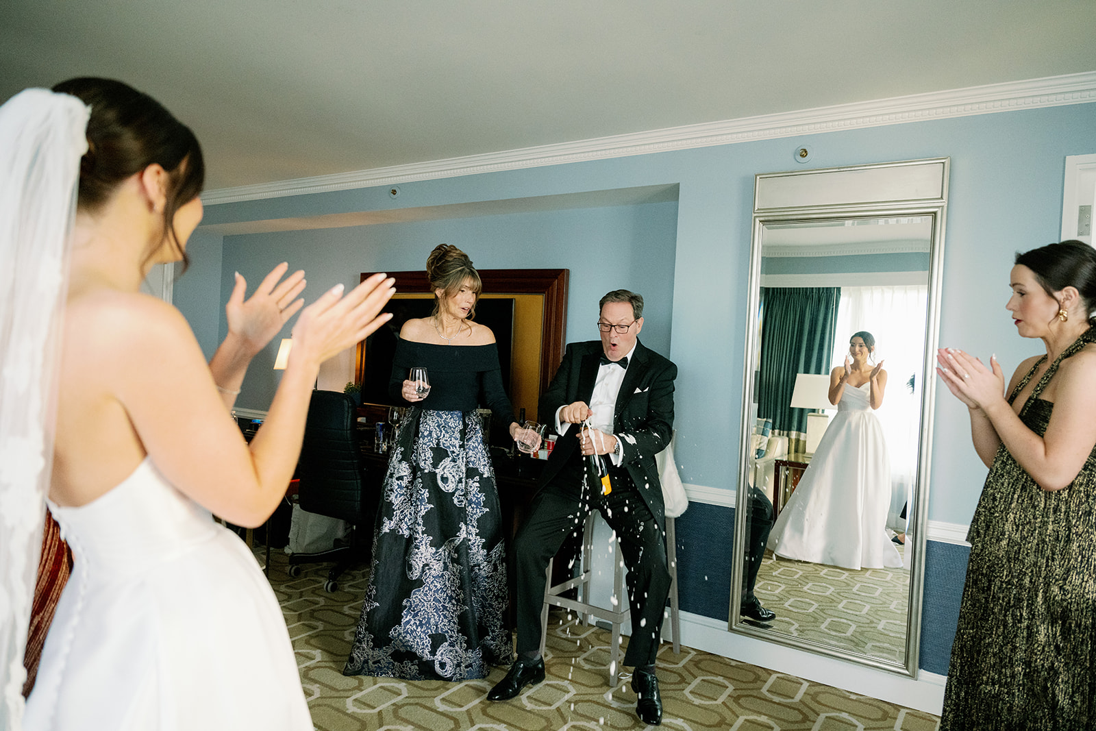 Bride's dad popping a bottle of champagne in the getting ready suite at the Boston Harbor Hotel. 