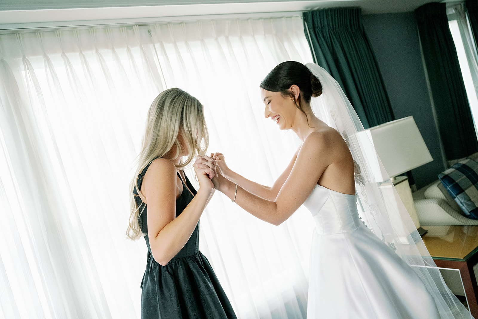 Bride and sister sharing a candid moment after getting ready. 