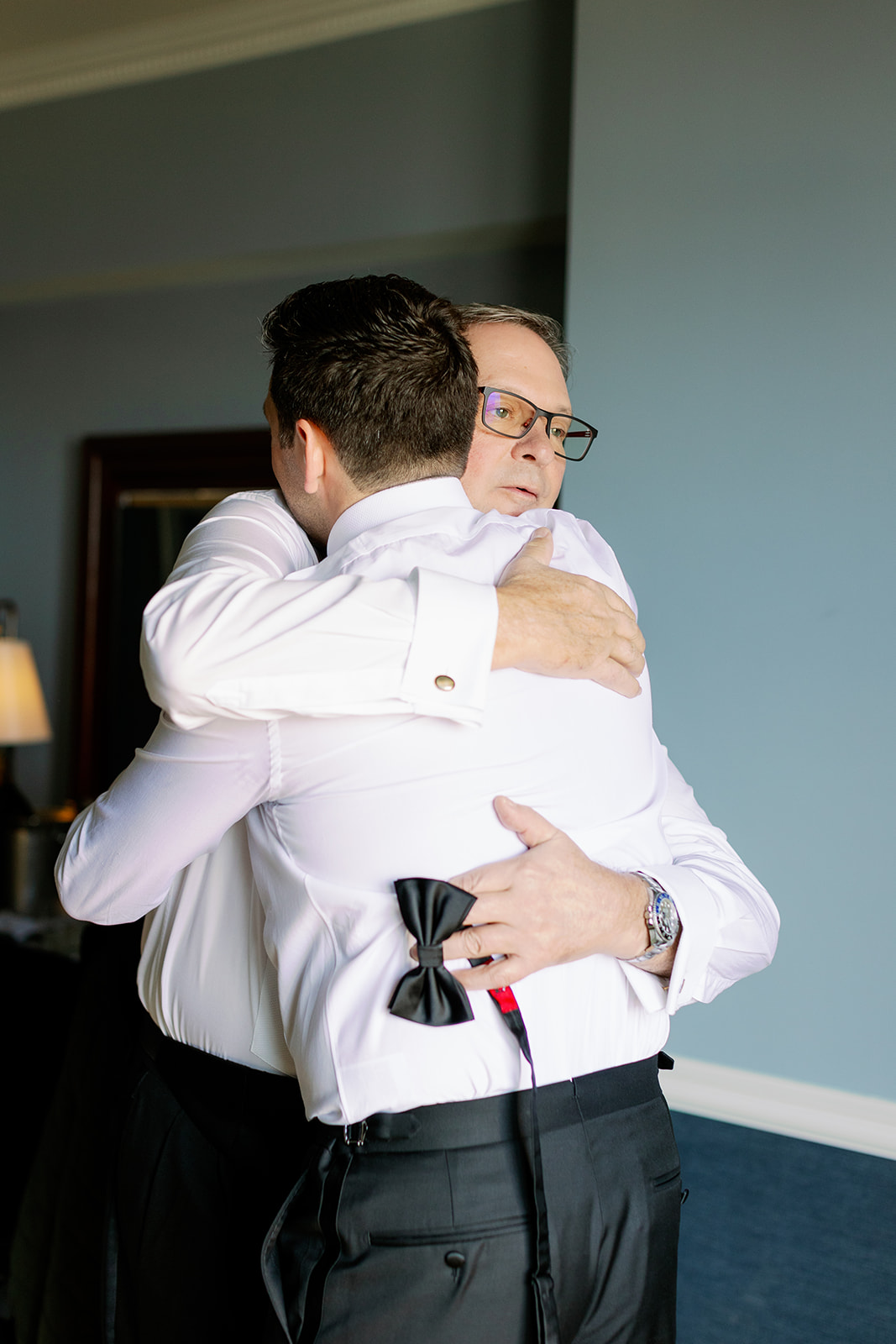 Groom and bride's dad sharing a candid hug. 