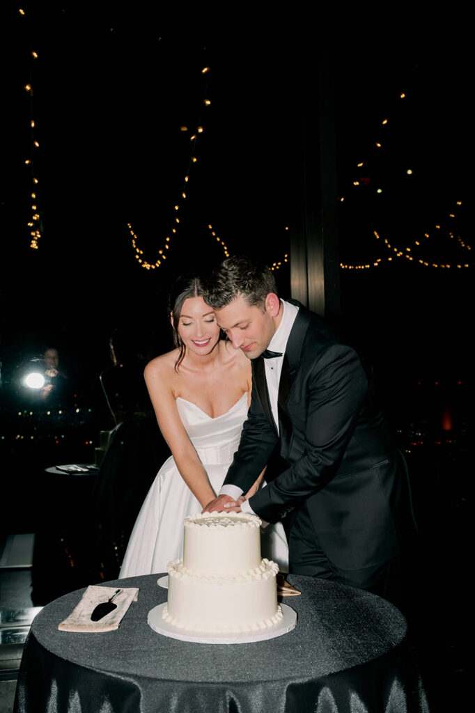 Bride and groom Boston State Room wedding cake cutting flash photo.