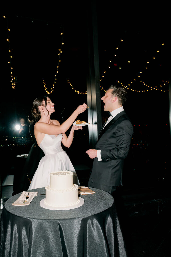 Candid bride and groom Boston State Room wedding cake cutting flash photo.